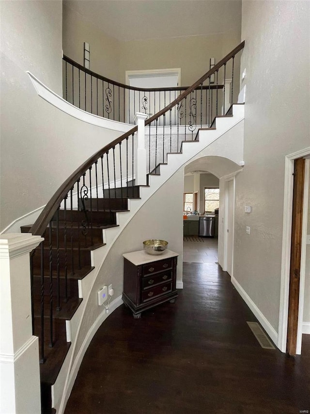 27302 Cimarron Dr, Roaring River Township, MO 65641 - stairway featuring arched walkways, a high ceiling, wood finished floors, and baseboards