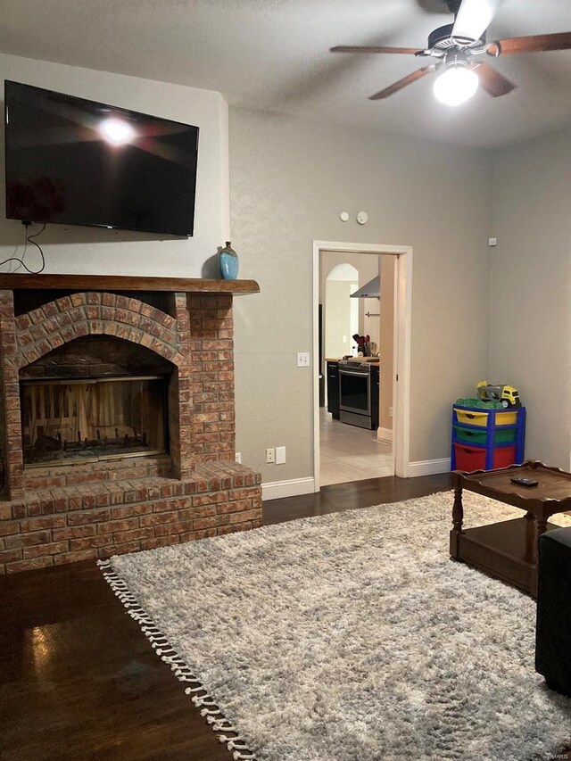 27302 Cimarron Dr, Roaring River Township, MO 65641 - living area featuring wood finished floors, a ceiling fan, baseboards, and a brick fireplace