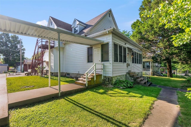 view of home's exterior featuring entry steps, a lawn, and stairs