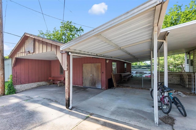 view of vehicle parking featuring a carport and fence