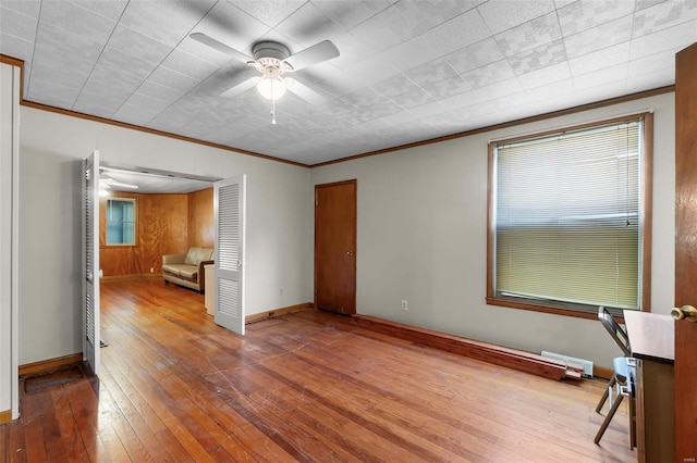 unfurnished bedroom with ornamental molding, hardwood / wood-style flooring, baseboards, multiple windows, and a closet