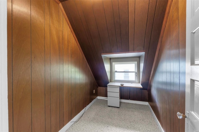 bonus room featuring wood walls, light colored carpet, and baseboards