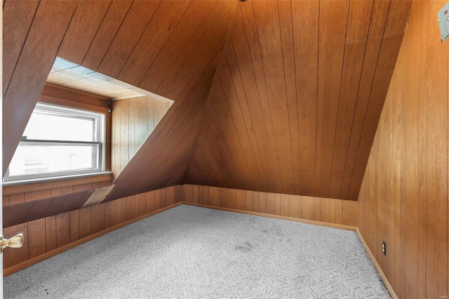 bonus room with wooden walls and carpet floors