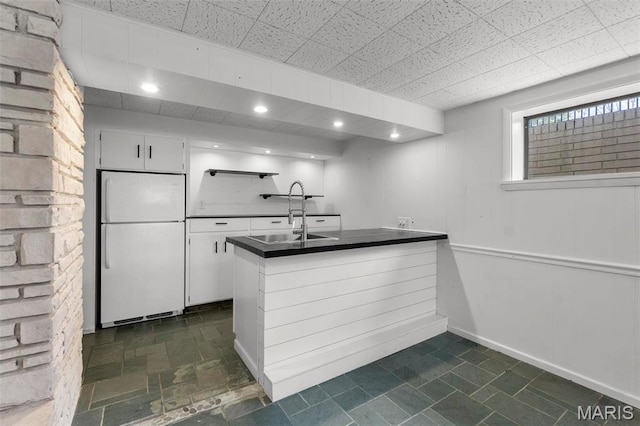 1331 N Cape Rock Dr, Cape Girardeau, MO 63701 - kitchen featuring freestanding refrigerator, dark countertops, a sink, a peninsula, and white cabinets