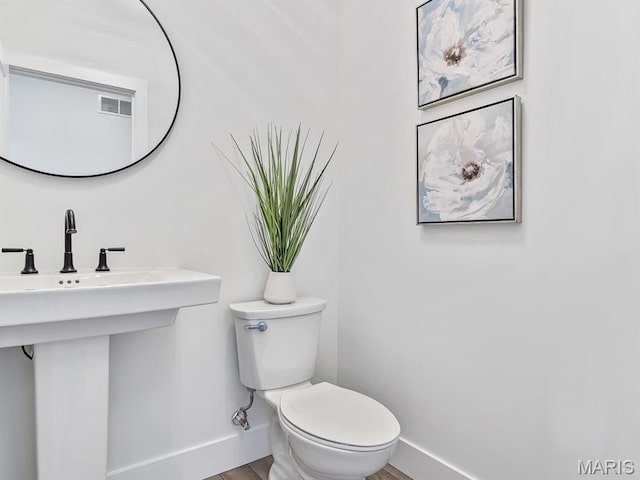 3106 Ashley Dr, Glen Carbon, IL 62034 - bathroom with baseboards, toilet, and wood finished floors