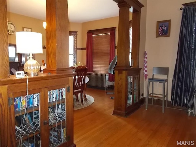 1001 S Main St, Lockwood, MO 65682 - dining room featuring radiator heating unit, wood finished floors, plenty of natural light, and decorative columns