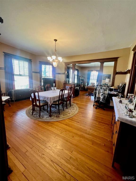 1001 S Main St, Lockwood, MO 65682 - dining area featuring a chandelier, light wood-type flooring, and radiator heating unit