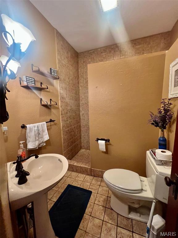 1001 S Main St, Lockwood, MO 65682 - bathroom with toilet, a tile shower, and tile patterned flooring