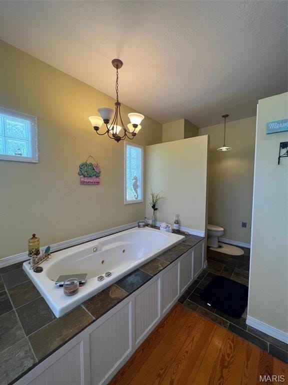 1001 S Main St, Lockwood, MO 65682 - bathroom featuring a whirlpool tub, toilet, baseboards, and a chandelier