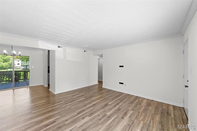 1509 Swallow Dr, Saint Louis, MO 63144 - empty room with wood finished floors, a textured ceiling, a chandelier, crown molding, and baseboards