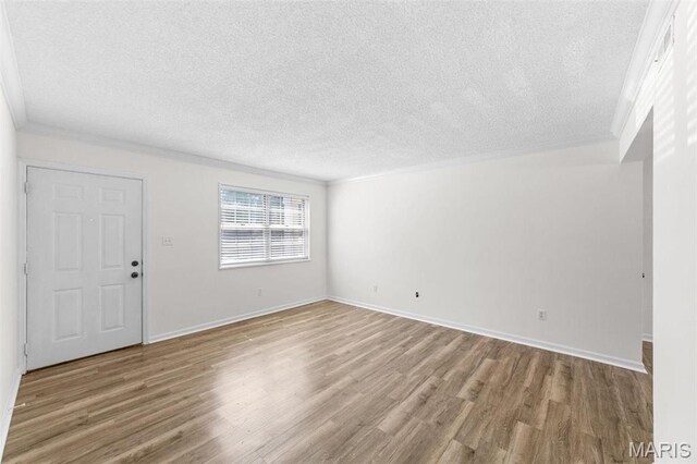 1509 Swallow Dr, Saint Louis, MO 63144 - unfurnished living room featuring wood finished floors, a textured ceiling, ornamental molding, and baseboards