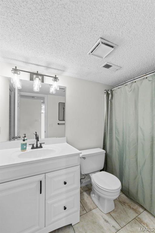 1509 Swallow Dr, Saint Louis, MO 63144 - bathroom featuring vanity, toilet, a textured ceiling, and curtained shower