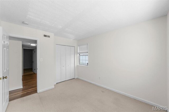 1509 Swallow Dr, Saint Louis, MO 63144 - unfurnished bedroom with carpet floors, a closet, baseboards, and a textured ceiling