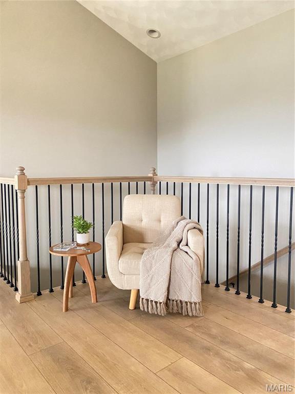 sitting room featuring light wood-style floors and an upstairs landing