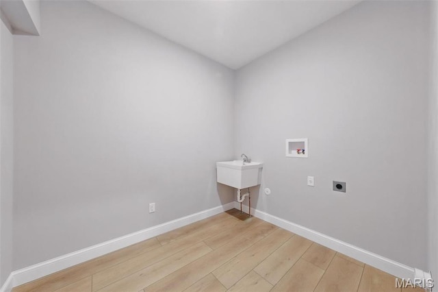 laundry room featuring electric dryer hookup, light wood-style floors, baseboards, and hookup for a washing machine