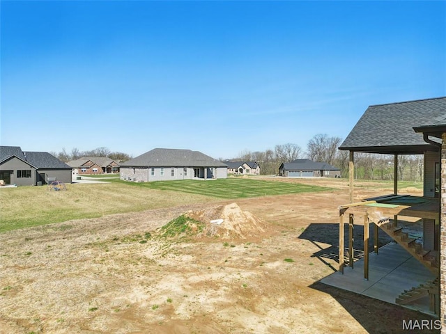 view of green lawn with a residential view