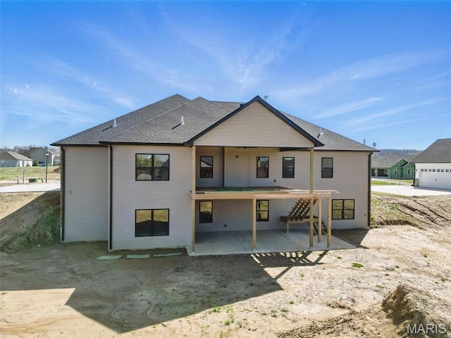 back of house with a patio and a shingled roof