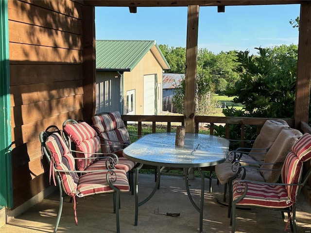 view of wooden balcony featuring outdoor dining area and a deck