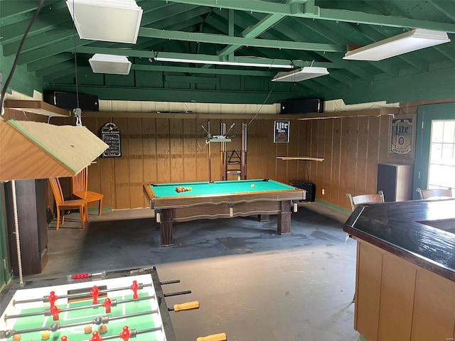game room with wooden walls, unfinished concrete floors, pool table, and lofted ceiling
