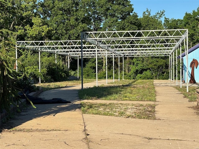 view of parking featuring view of wooded area