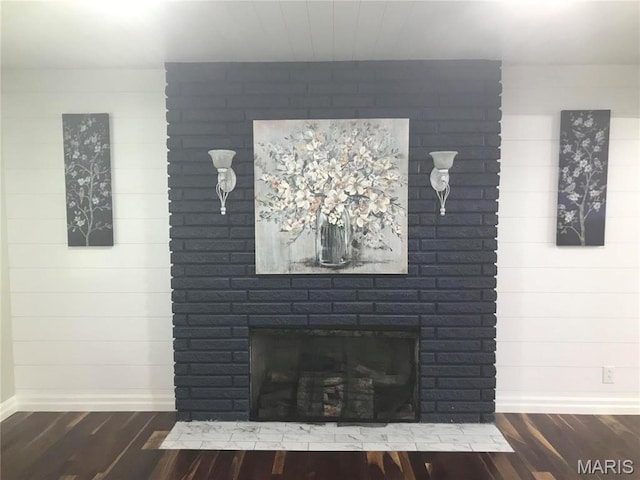 1202 S Gertrude St, Salem, MO 65560 - detailed view of wood finished floors, a brick fireplace, and wooden walls