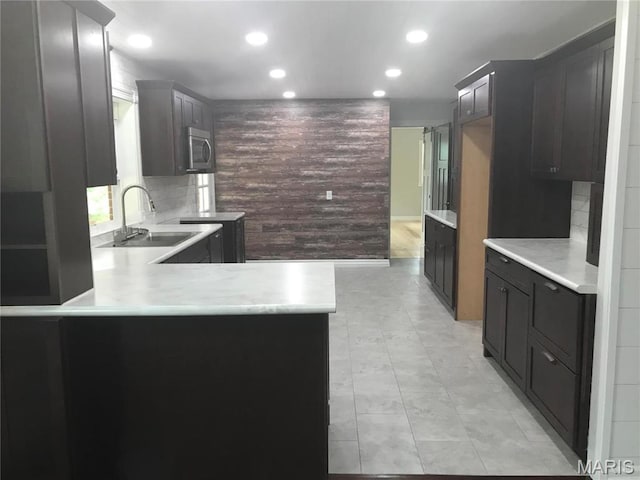 1202 S Gertrude St, Salem, MO 65560 - kitchen with stainless steel microwave, recessed lighting, a peninsula, backsplash, and light countertops