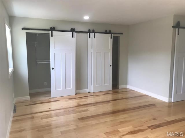 1202 S Gertrude St, Salem, MO 65560 - unfurnished bedroom with a barn door, light wood-style flooring, and recessed lighting