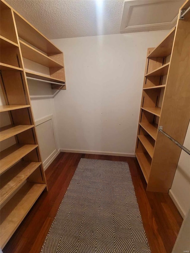 walk in closet featuring dark wood finished floors and attic access