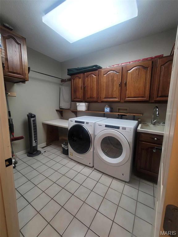 16225 Shady Ln, Dexter, MO 63841 - clothes washing area featuring cabinet space, light tile patterned flooring, and washer and dryer