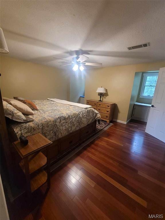 16225 Shady Ln, Dexter, MO 63841 - bedroom featuring dark wood finished floors, a textured ceiling, a ceiling fan, and baseboards