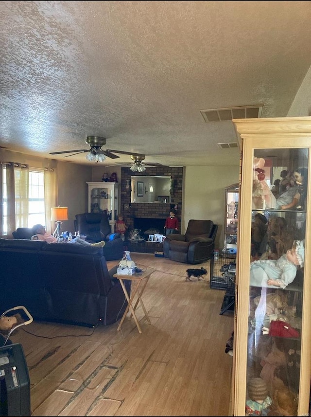 131 W Outer Rd, Poplar Bluff, MO 63901 - living area with a ceiling fan, a textured ceiling, wood finished floors, and a brick fireplace