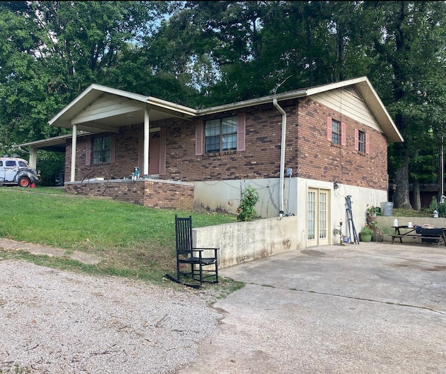 131 W Outer Rd, Poplar Bluff, MO 63901 - view of front facade with french doors, brick siding, concrete driveway, and a front yard