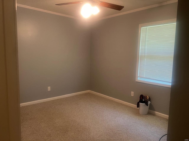 spare room with ceiling fan, carpet floors, crown molding, baseboards, and plenty of natural light