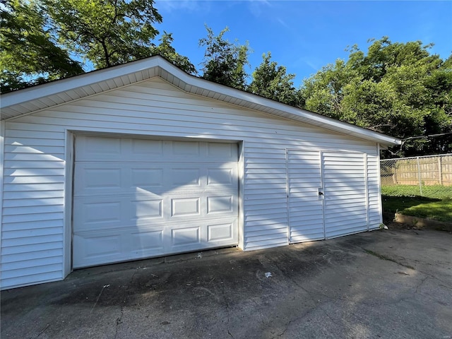 detached garage with fence and driveway