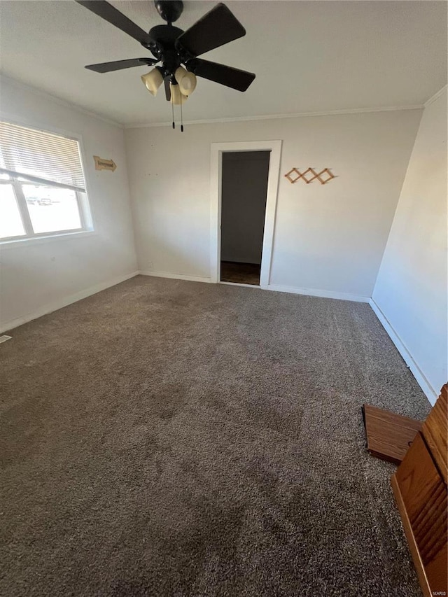 unfurnished room featuring carpet floors, ornamental molding, ceiling fan, and baseboards