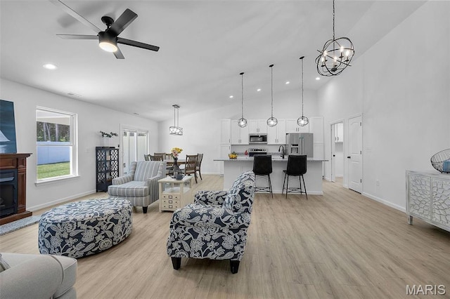 1523 Hickory Lndg, De Soto, MO 63020 - living area featuring light wood-style flooring, a chandelier, baseboards, recessed lighting, and high vaulted ceiling