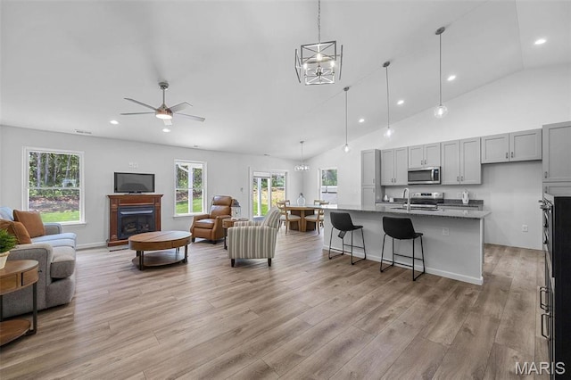 1523 Hickory Lndg, De Soto, MO 63020 - living area with plenty of natural light, light wood finished floors, recessed lighting, a glass covered fireplace, and a ceiling fan