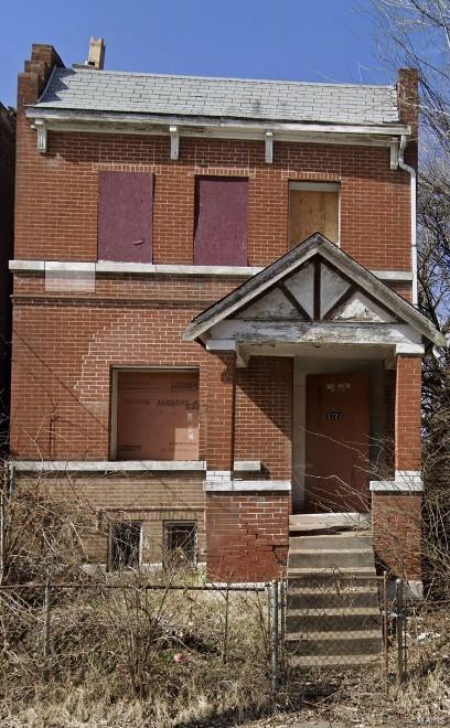 view of front facade with brick siding and fence