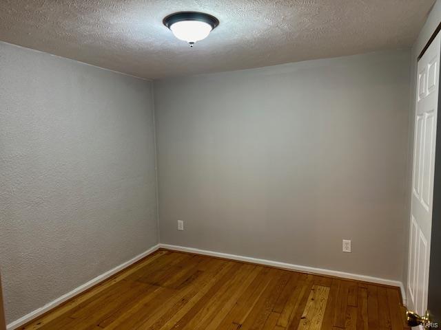 13 N Division St, Duquoin, IL 62832 - empty room with wood finished floors, baseboards, and a textured ceiling
