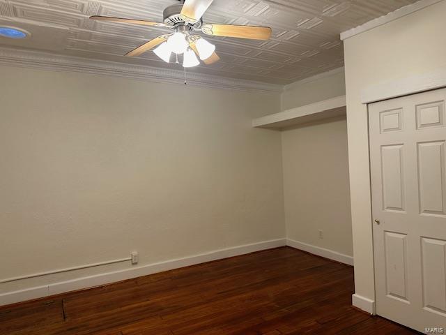 13 N Division St, Duquoin, IL 62832 - unfurnished bedroom featuring crown molding, baseboards, dark wood-type flooring, an ornate ceiling, and ceiling fan