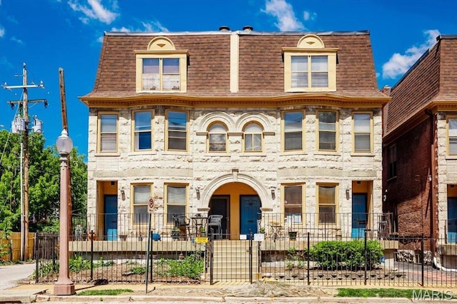 329 N Boyle Ave Unit A, Saint Louis, MO 63108 - view of property with a shingled roof, a fenced front yard, mansard roof, and stone siding