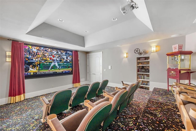 home theater room with a raised ceiling, baseboards, carpet, and recessed lighting