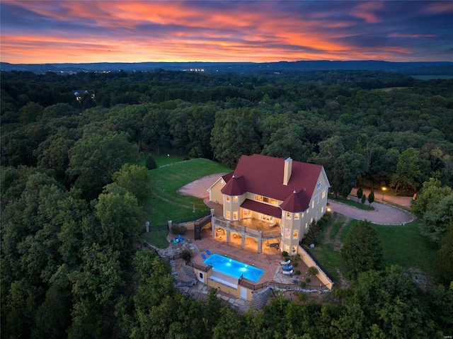 view from above of property with a forest and a pool area