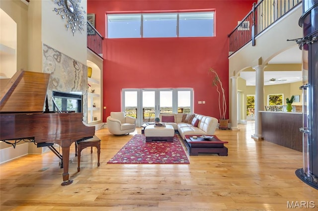 265 Deer Run Ln, Eureka, MO 63025 - living area with ornate columns, arched walkways, a towering ceiling, built in features, and hardwood / wood-style floors