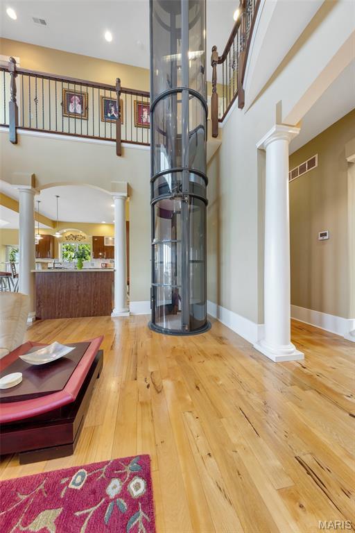265 Deer Run Ln, Eureka, MO 63025 - foyer with decorative columns, a high ceiling, wood-type flooring, and baseboards