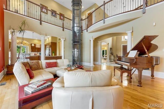 265 Deer Run Ln, Eureka, MO 63025 - living area with decorative columns, arched walkways, wood finished floors, a high ceiling, and baseboards