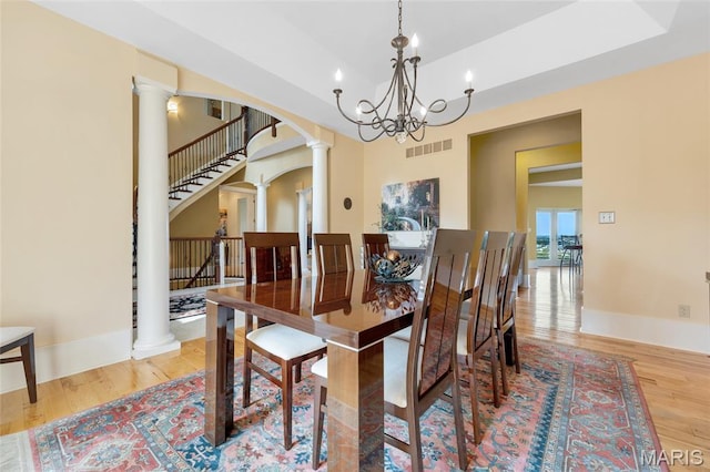 265 Deer Run Ln, Eureka, MO 63025 - dining area featuring decorative columns, wood finished floors, arched walkways, stairs, and a chandelier