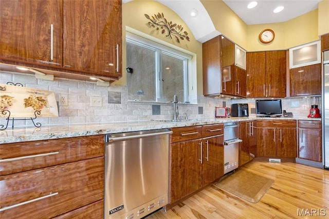 265 Deer Run Ln, Eureka, MO 63025 - kitchen featuring dishwasher, a sink, light wood-style floors, light stone countertops, and backsplash