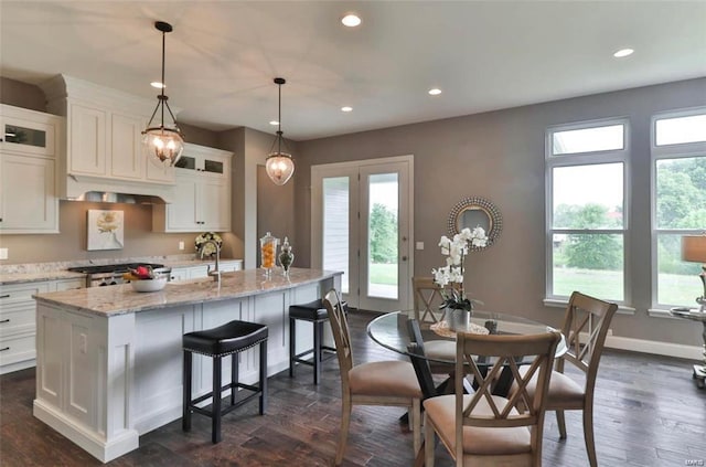 2626 Center Ave, Wildwood, MO 63040 - kitchen featuring a kitchen island with sink, white cabinets, glass insert cabinets, recessed lighting, and light stone counters