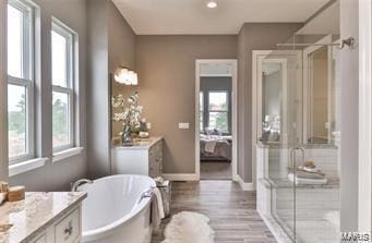 2626 Center Ave, Wildwood, MO 63040 - full bathroom featuring a shower stall, a freestanding tub, vanity, wood finished floors, and baseboards
